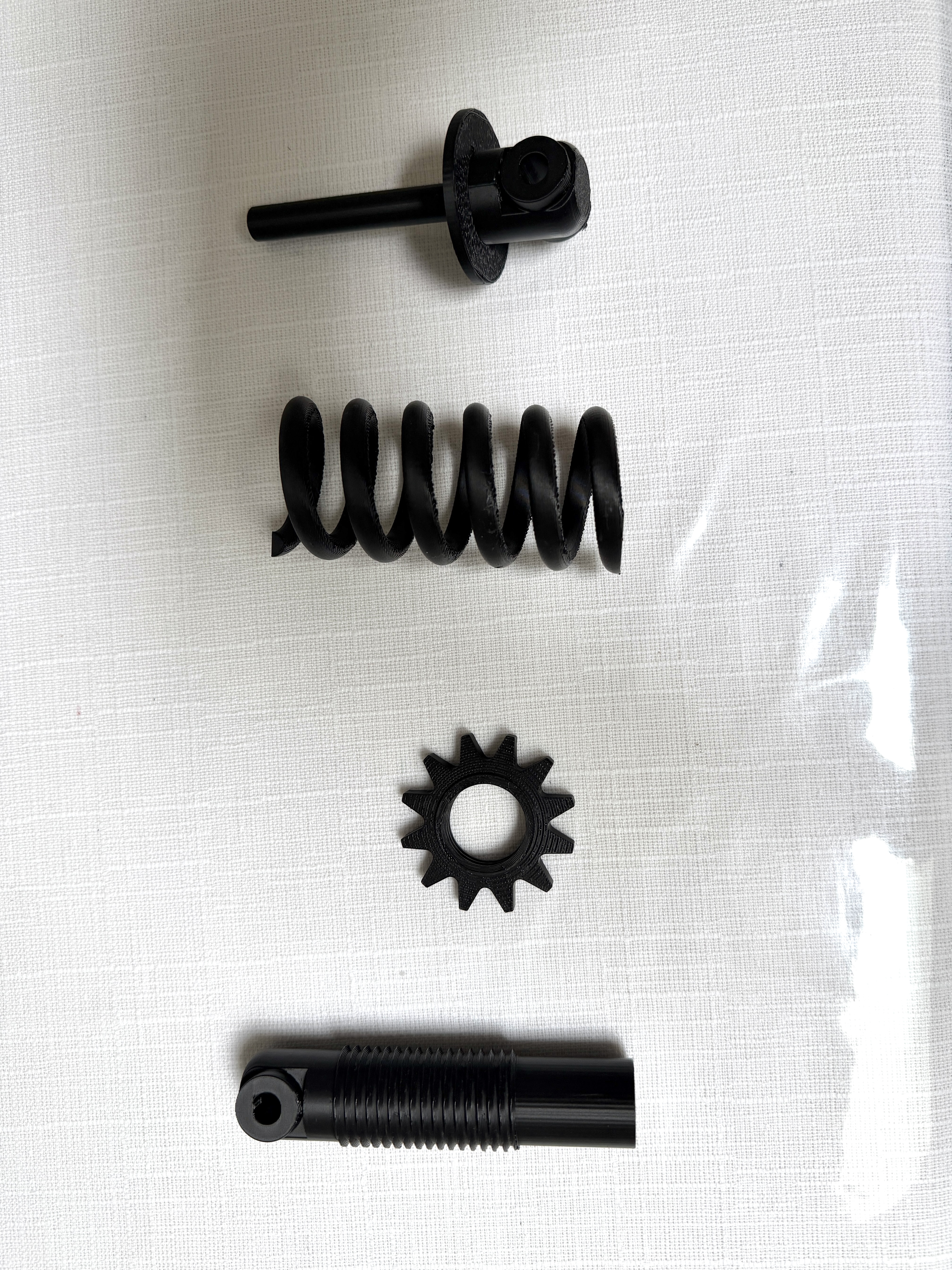 Printed PLA coilover components laid out separately